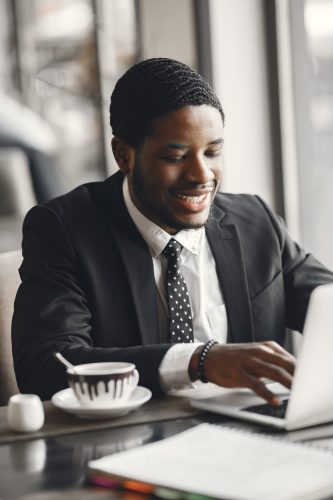 african-american-businessman-using-laptop-cafe-min